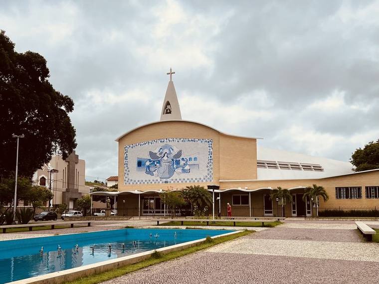 The Santuário de Santa Rita de Cássia, a modernist church with a curved roofline, slender spire and a large blue-and-white tiled panel across its façade.